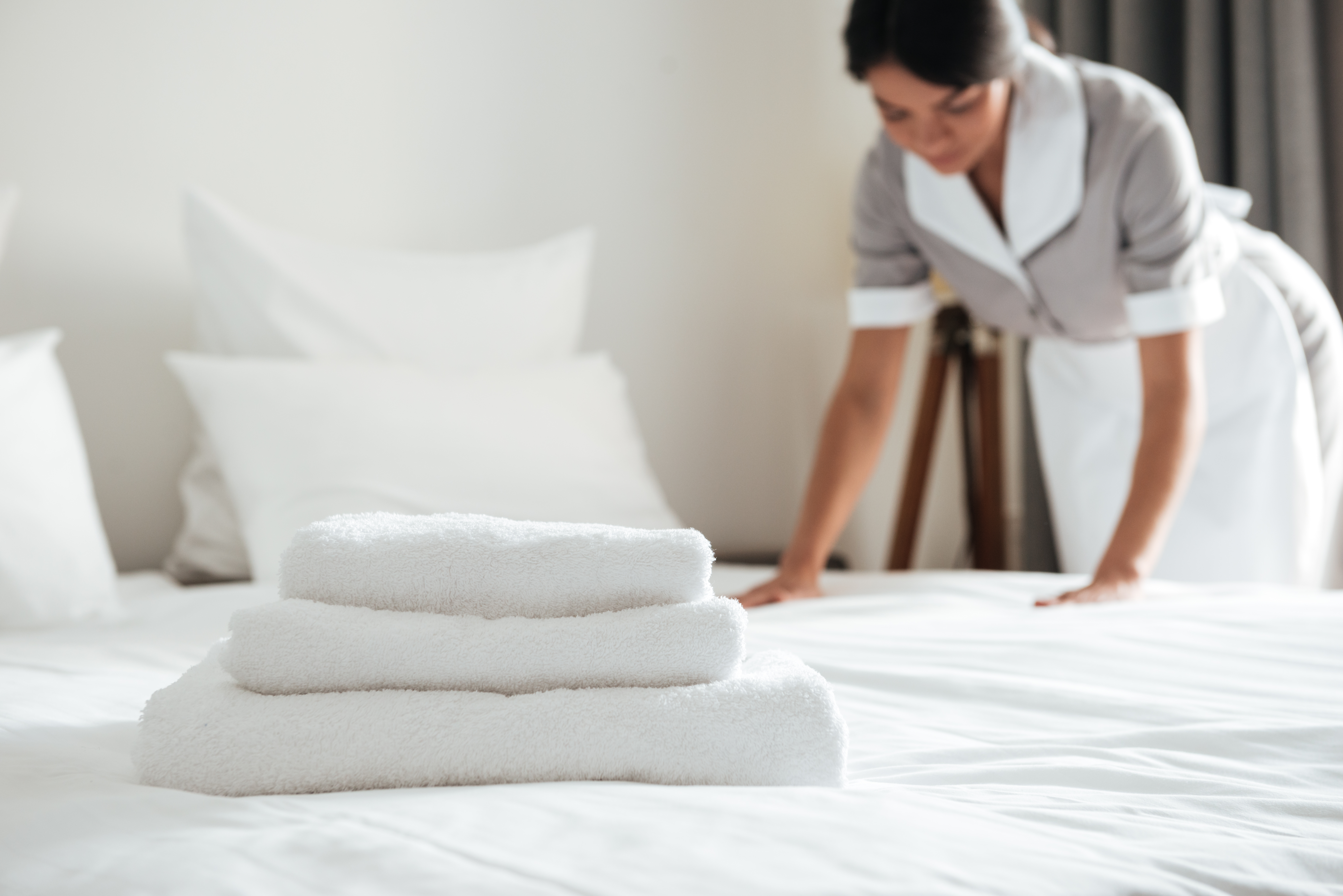 young-hotel-maid-setting-up-pillow-bed